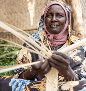 A woman weaving palm, Nyala camel market, South Darfur.