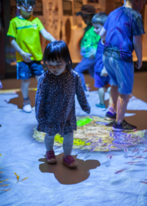 Children playing with an interactive floor projection at the Horniman Museum