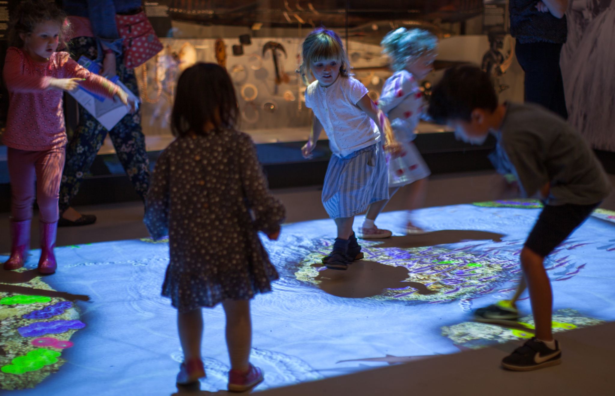 Children playing with an interactive floor projection at the Horniman Museum