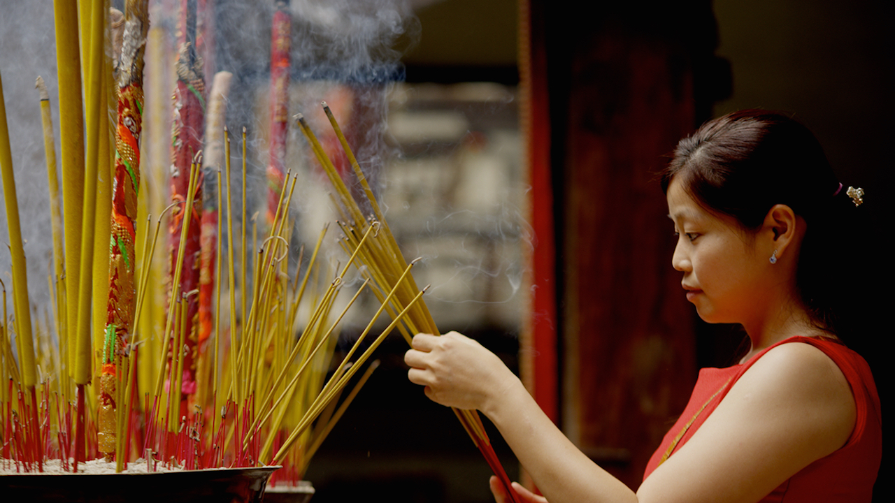 A worshipper burning incense at a Chinese Temple in Ho Chi Minh City, Vietnam.
